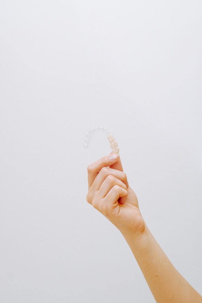 A close-up image of an Invisalign tray, a clear, removable aligner used for straightening teeth. The tray is transparent and fits snugly over the teeth, offering a discreet and convenient orthodontic solution by Aspen Dental Care, the leading dental clinic in Calgary.